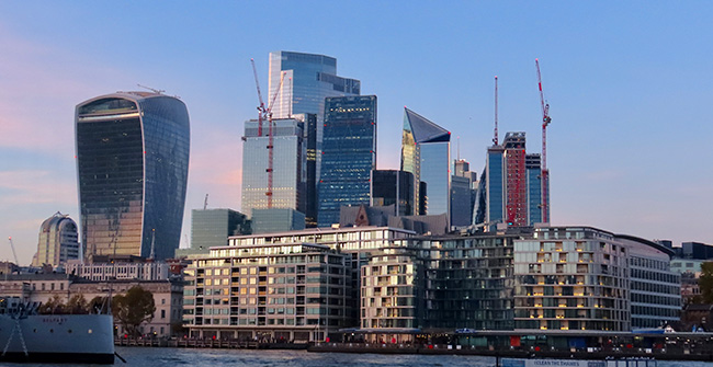 modern-buildings-city-against-sky .net projects and clients represented by .net logo over tower bridge